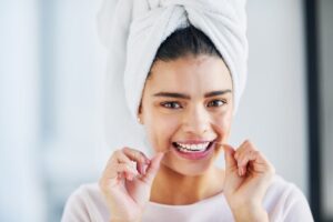 woman who just came out of the shower flossing