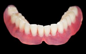 lower denture against a black background
