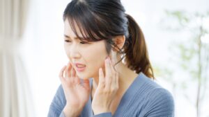 Woman holding her jaw and appearing uncomfortable